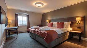 Kahden huoneen sviitti kahden hengen vuoteella ja pöydällä Clarion Collection Hotel Uman -hotellissa, Uumajassa