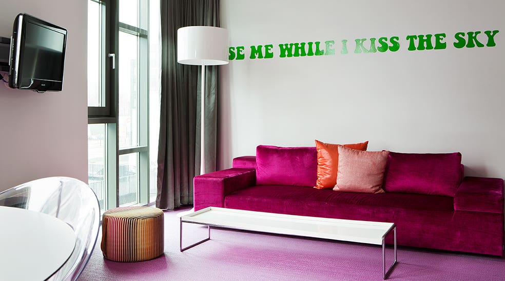 Sviitti Flowerpower roosa sohva ja vihreä teksti seinällä Comfort Hotel Union Bryggessä, Drammenissa