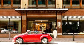 Punainen avoauto pysäköitynä Hotel F6 -hotellin sisäänkäynnin edessä – Helsingissä, Suomessa