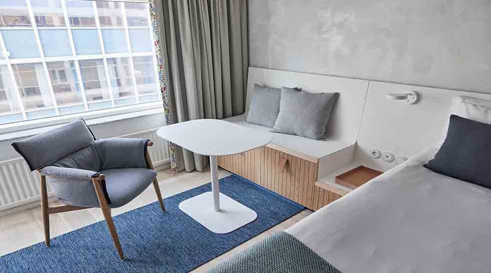 Istumapaikka pöydällä sekä skandinaavista designia oleva tuoli kahden hengen ikkunallisessa Superior-huoneessa, Nordic Light Hotel -hotellissa, Tukholmassa